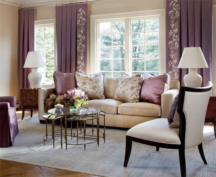 Фиолетовый цвет в интерьере бежевой гостиной представлен текстилем