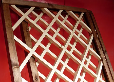 Деревянная решетка, созданная с использованием технологии перекрытия реек. Соединение защищено щелями.