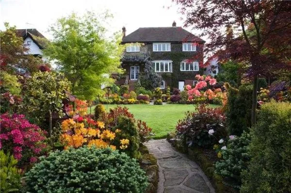 Пышная растительность перемежается ухоженными газонами - признаки английского сада